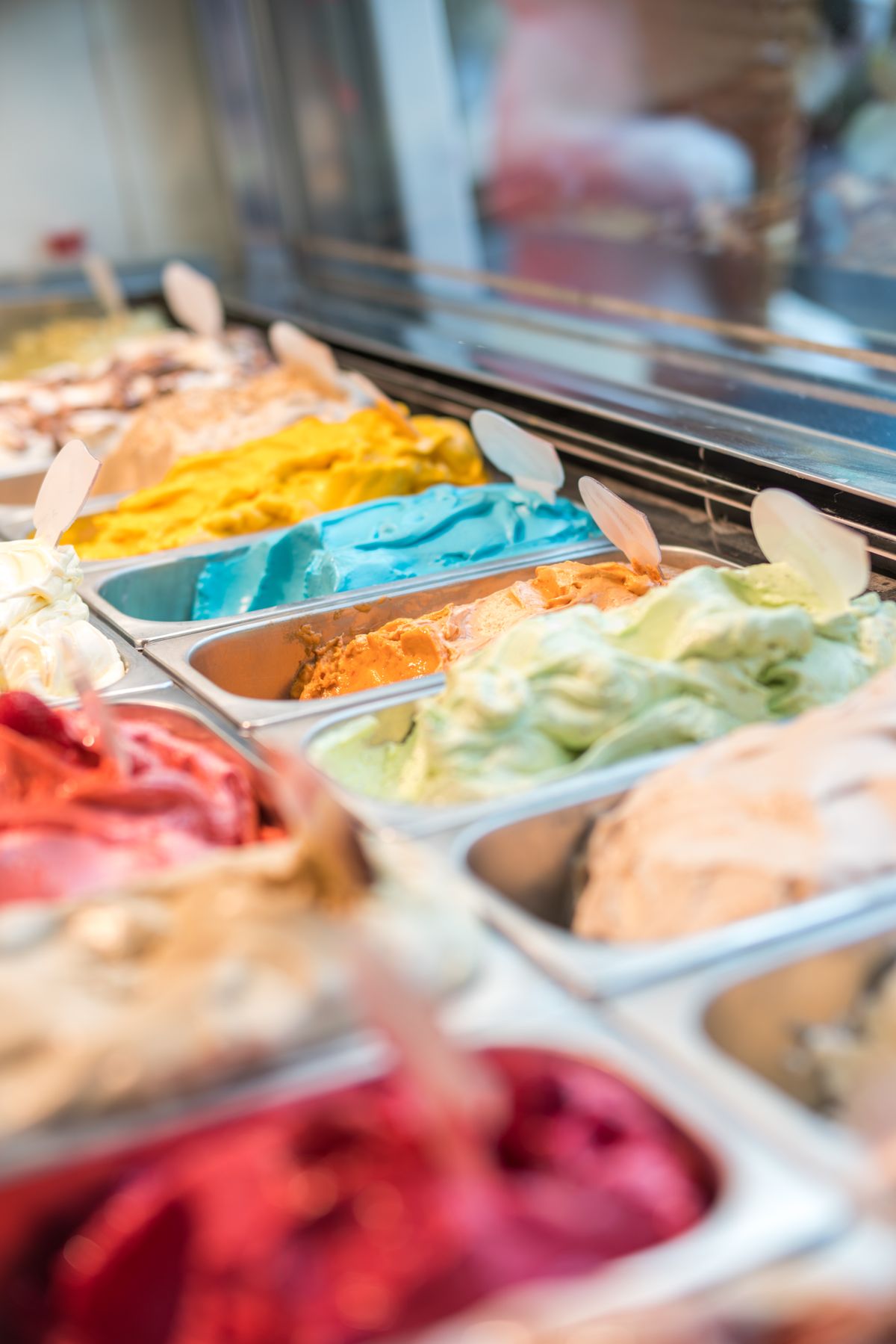 Vitrina de exhibición con variedad de sabores de helado artesanal de colores